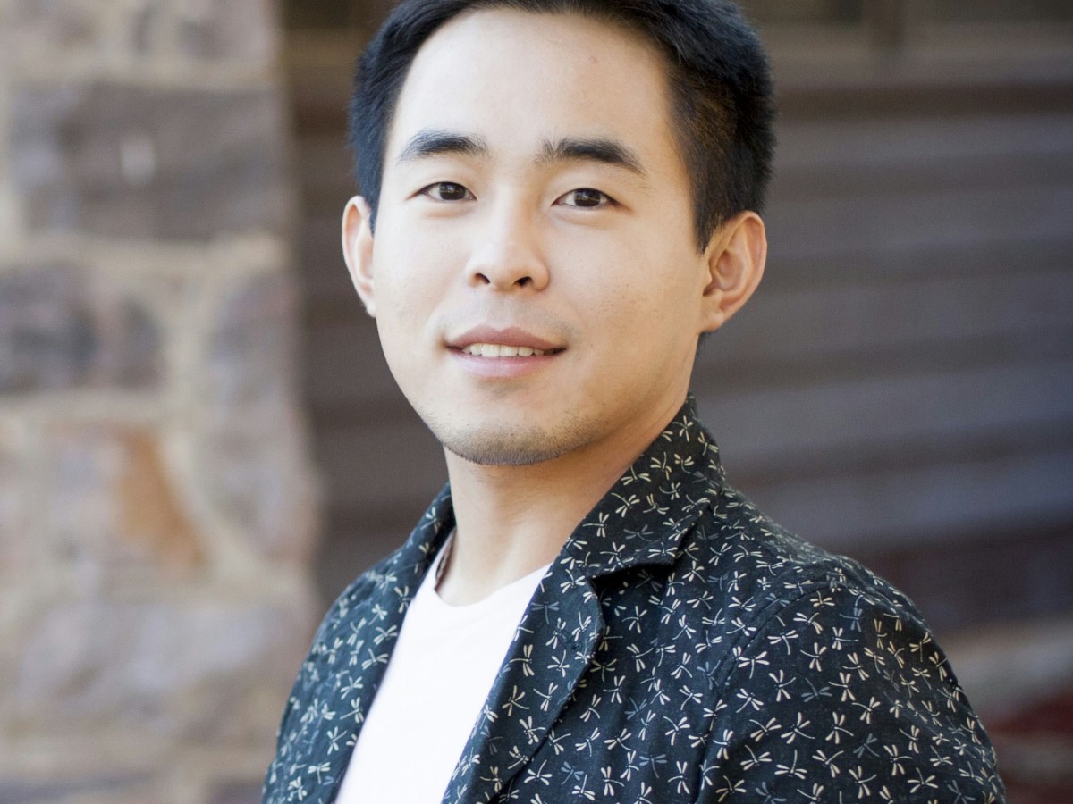 A headshot of Dr Yao Ding, the guest speaker at Something Digital. He is a young looking Asian man with black hair wearing a white tshirt under a patterned dark blue button up shirt.