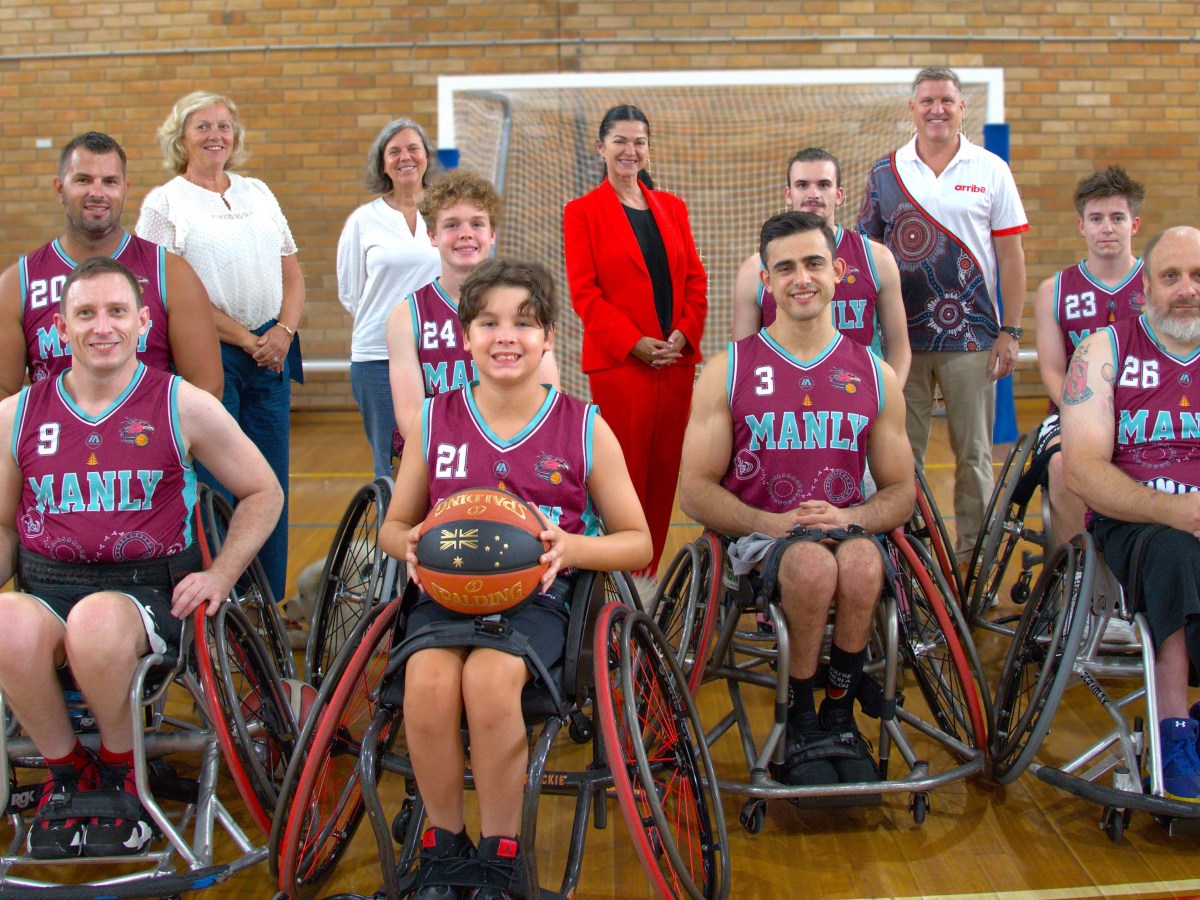 The Manly Wheel Eagles, a group of wheelchair basketball players, in their wheelchairs and red uniforms.