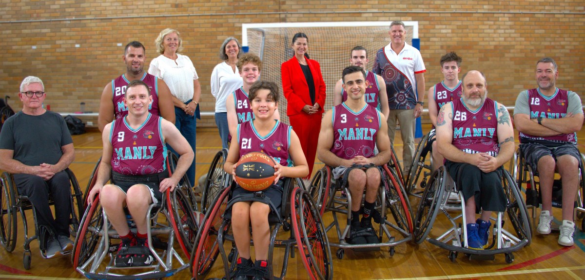 The Manly Wheel Eagles, a group of wheelchair basketball players, in their wheelchairs and red uniforms.