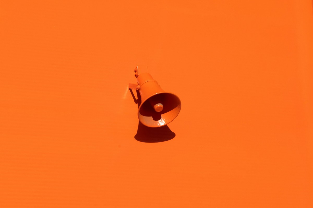 An orange megaphone on an orange background.