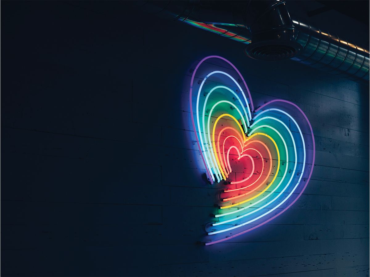 A rainbow neon light in a love heart shape